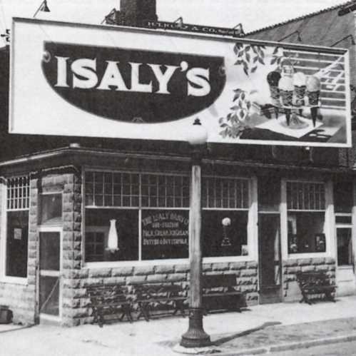 Historic black-and-white photo of Isaly's storefront with a large sign and outdoor seating.