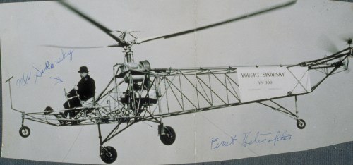 A historic photo of the Vought-Sikorsky VS-300 helicopter with a pilot seated, showcasing its unique design and structure.