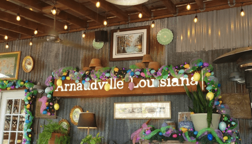 A cozy interior with festive decorations, including lights and colorful garlands, showcasing "Arnaudville, Louisiana."