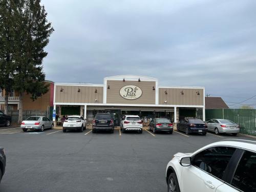Exterior of Pat's store with parked cars in front and a cloudy sky above.