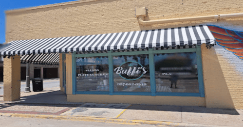 Exterior of Buffi's restaurant with a striped awning, featuring large windows displaying the menu and a colorful mural.