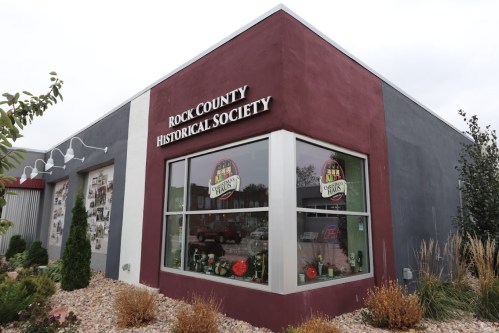 Exterior of the Rock County Historical Society building, featuring large windows and a colorful sign.