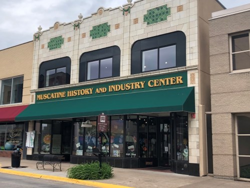 Exterior of the Muscatine History and Industry Center, featuring a green awning and decorative tile facade.