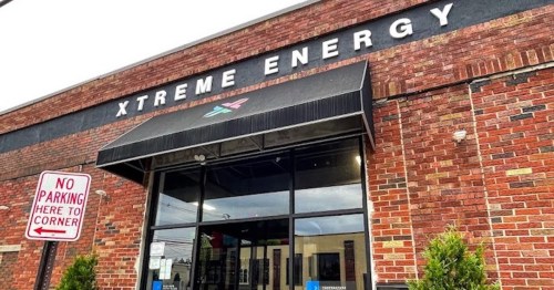 Exterior of a brick building with a sign that reads "Xtreme Energy" and a no parking sign nearby.