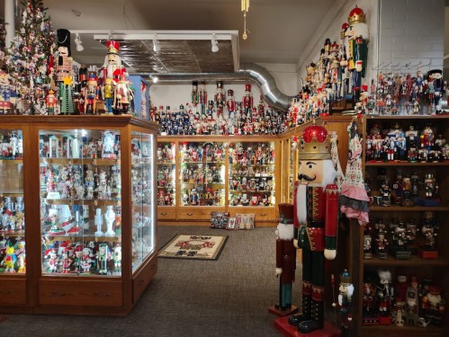 A festive room filled with numerous nutcracker figurines and display cases, creating a vibrant holiday atmosphere.
