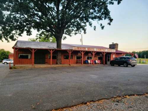 A rustic red building with a sign reading "Wagon Wheel Country Cafe," surrounded by trees and parked cars.