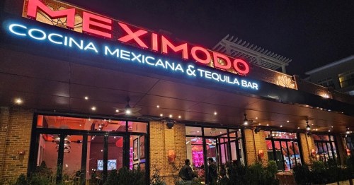 Exterior of Meximodo Cocina Mexicana & Tequila Bar at night, featuring bright signage and a welcoming atmosphere.