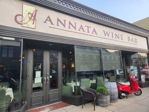 Exterior of Annata Wine Bar featuring a welcoming entrance, outdoor seating, and a red scooter parked nearby.