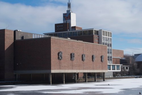 Exterior view of the Museum of Science, featuring a brick building and a prominent butterfly sculpture on the roof.