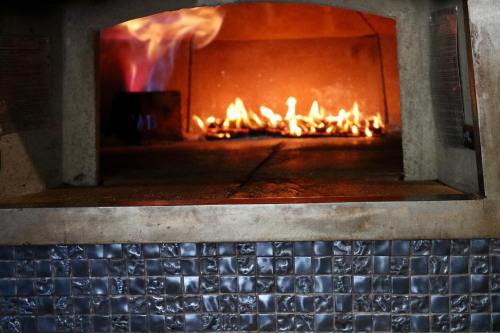 A view of a brick oven with flames and glowing embers, showcasing a warm, inviting cooking environment.