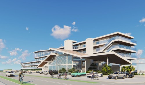 Modern multi-story building with a sleek design, surrounded by cars and cyclists, set against a clear blue sky.