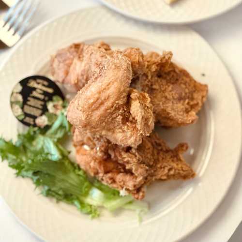 Crispy fried chicken pieces served on a plate with a garnish of lettuce.