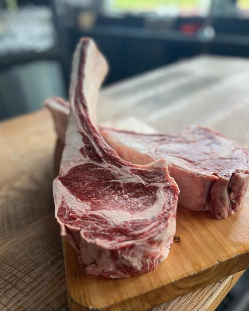 A close-up of a marbled ribeye steak on a wooden cutting board, showcasing its rich texture and color.