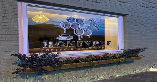 A window display for "Honeybee Coffee & Donut House" featuring honeycomb and a bee illustration, with flowers below.