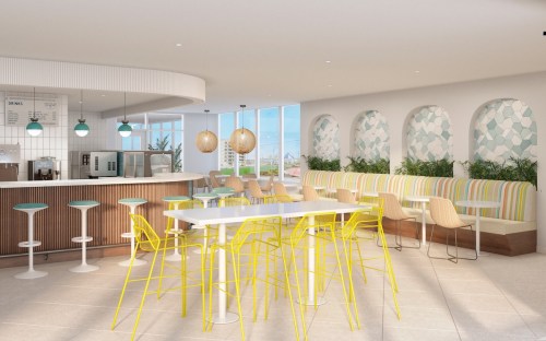 Bright, modern café interior with colorful seating, a bar area, and large windows letting in natural light.