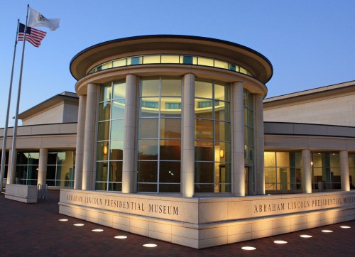 Exterior view of the Abraham Lincoln Presidential Museum, featuring modern architecture and illuminated signage.