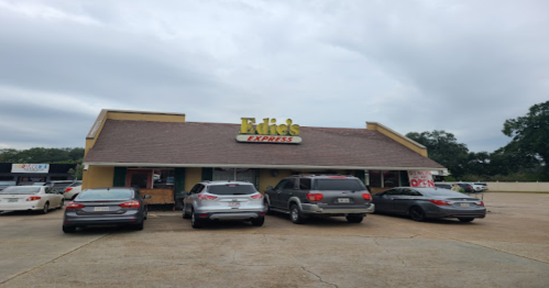 A restaurant named "Eddie's Express" with several cars parked outside under a cloudy sky.