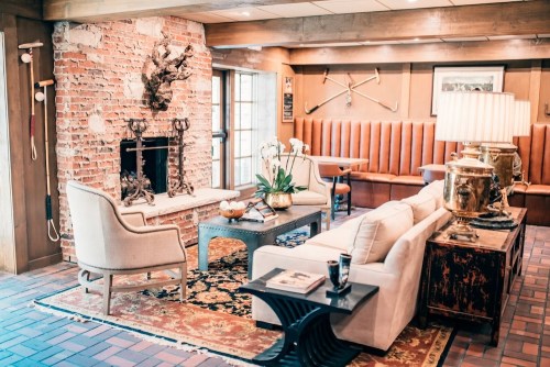 Cozy living room with a brick fireplace, elegant furniture, and decorative accents, creating a warm, inviting atmosphere.