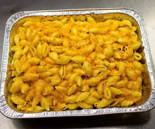 A large aluminum tray filled with creamy, baked macaroni and cheese.