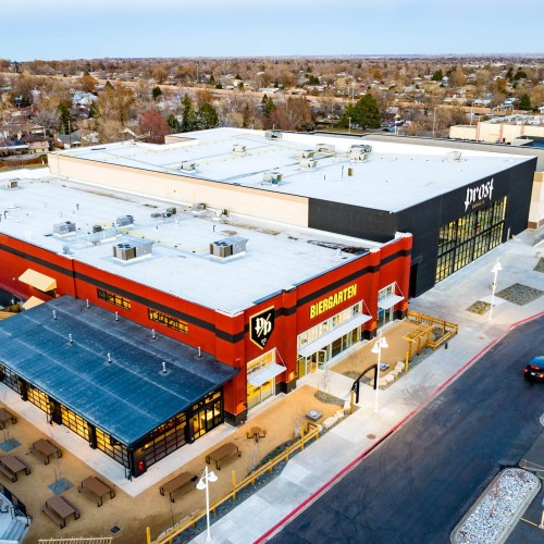 Aerial view of a large building with a red exterior labeled "Biergarten" and a black section labeled "Prost."