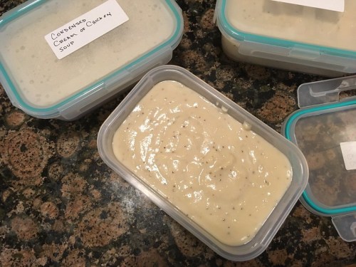 Containers of homemade condensed cream of chicken soup on a granite countertop.