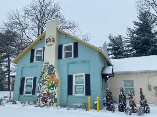 A colorful building with a floral mural, surrounded by snow and trees, on a winter day.