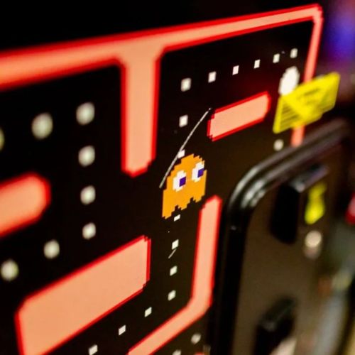 Close-up of a classic arcade game screen featuring a pixelated character navigating a maze.