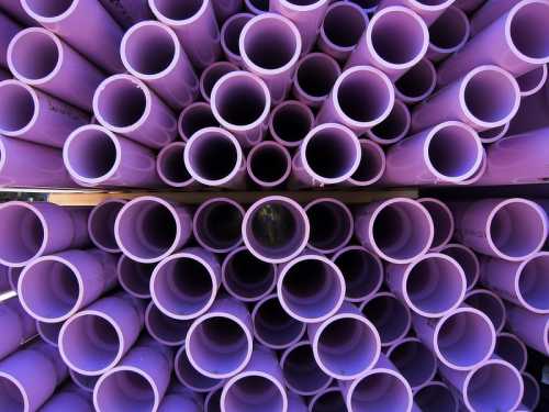 A close-up view of stacked purple PVC pipes arranged in a circular pattern.