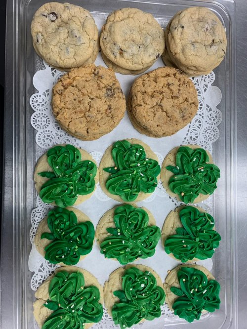 A tray of assorted cookies: chocolate chip, oatmeal, and green frosted cookies with sprinkles.