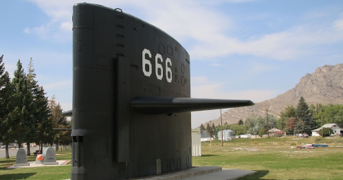 A large black submarine display with the number 666, set against a backdrop of trees and mountains.