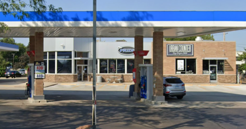 A gas station with two buildings: one branded "Pride" and the other "Heartland," featuring fuel pumps in front.