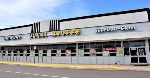 Exterior of Yuki Byuffe restaurant featuring a sushi buffet and seafood grill, with large windows and a clear blue sky.