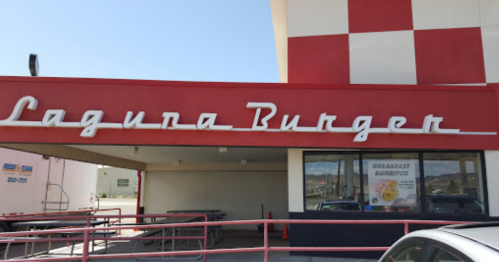 Sign for Lagura Burger with a red and white checkered background, featuring a window advertising breakfast burritos.