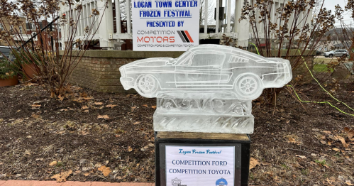 Ice sculpture of a classic car at the Logan Town Center Frozen Festival, with a sign for Competition Motors.