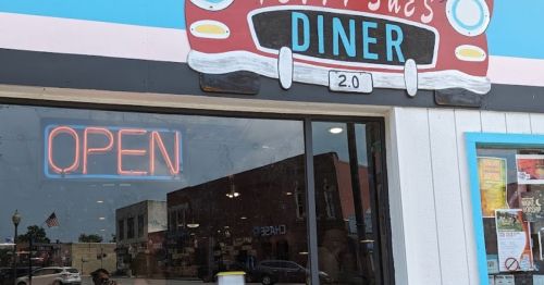 A colorful diner sign with a vintage car design, featuring an "OPEN" neon sign in the window.