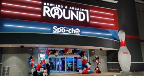 Entrance of Round1 Bowling & Arcade, featuring colorful balloon decorations and a large bowling pin sign.