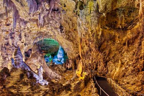 A colorful cave interior with stalactites and stalagmites, featuring a winding pathway through the rock formations.