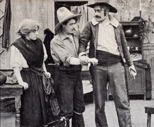 A vintage scene featuring three characters: a woman in period clothing, a man in a hat, and another man in western attire.