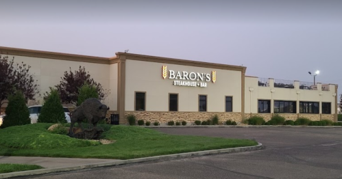 Exterior view of Baron's Steakhouse & Bar, featuring a sign and landscaped surroundings.