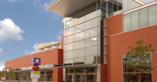 Modern building with large glass windows and red brick exterior, featuring a sign for the "Science Center of Iowa."