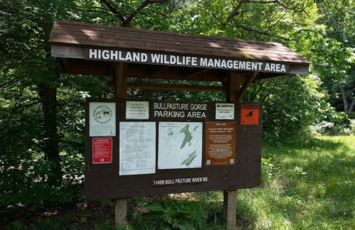 Sign for Highland Wildlife Management Area, featuring maps and information about Bullpasture Gorge parking area.