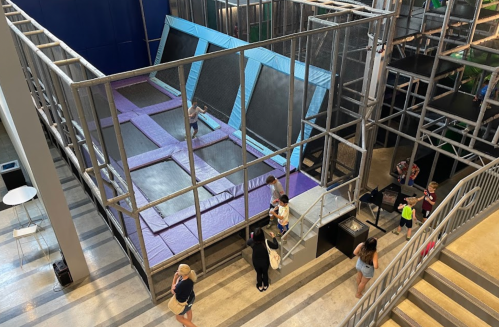 A view of a trampoline park with multiple trampolines and people enjoying the space.