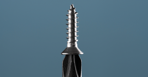 Close-up of a metal screw with a black head, set against a smooth blue background.
