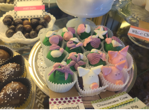 Colorful, decorative candies shaped like sea creatures and animals, displayed on a tray with labels.