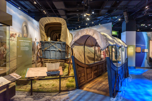 A historical exhibit featuring covered wagons and artifacts related to westward expansion.