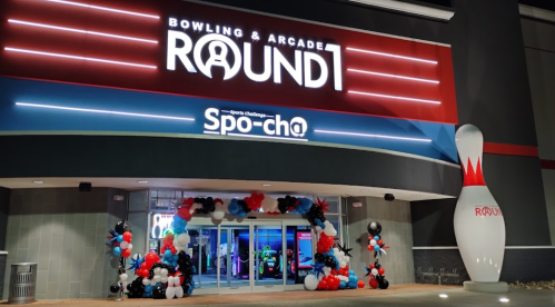 Entrance of Round 1 bowling and arcade, decorated with red, white, and black balloons, featuring a large bowling pin.