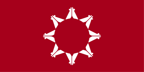 A red flag featuring a white circular design with eight stylized figures arranged in a star pattern.