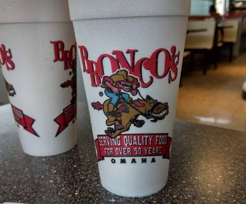 A foam cup with "Bronco's" logo featuring a cowboy on a horse, promoting quality food for over 50 years in Omaha.