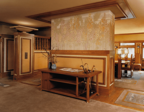 A cozy interior featuring wooden furniture, a decorative wall mural, and a warm color palette in a spacious living area.