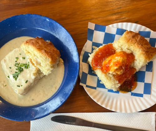 A blue plate with a biscuit and creamy sauce, alongside a white plate with a biscuit topped with orange jam.
